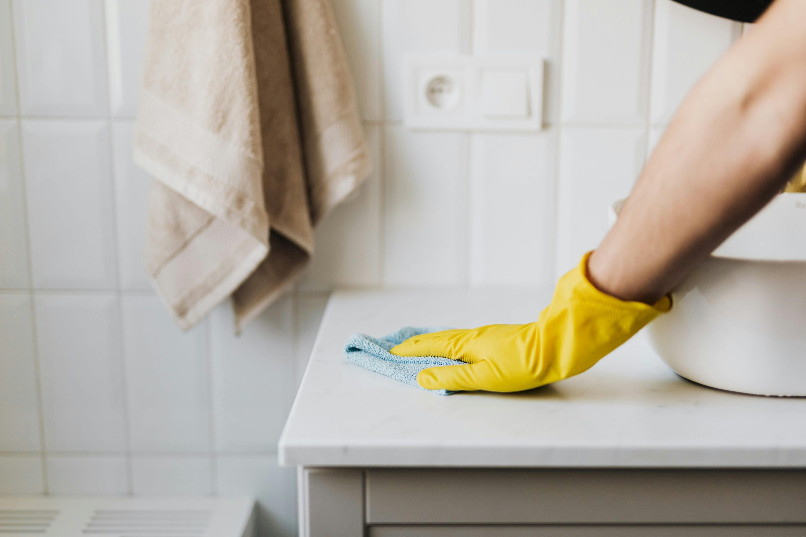 Commercial cleaner wiping bathroom countertop during professional office cleaning service in Logan and Beenleigh