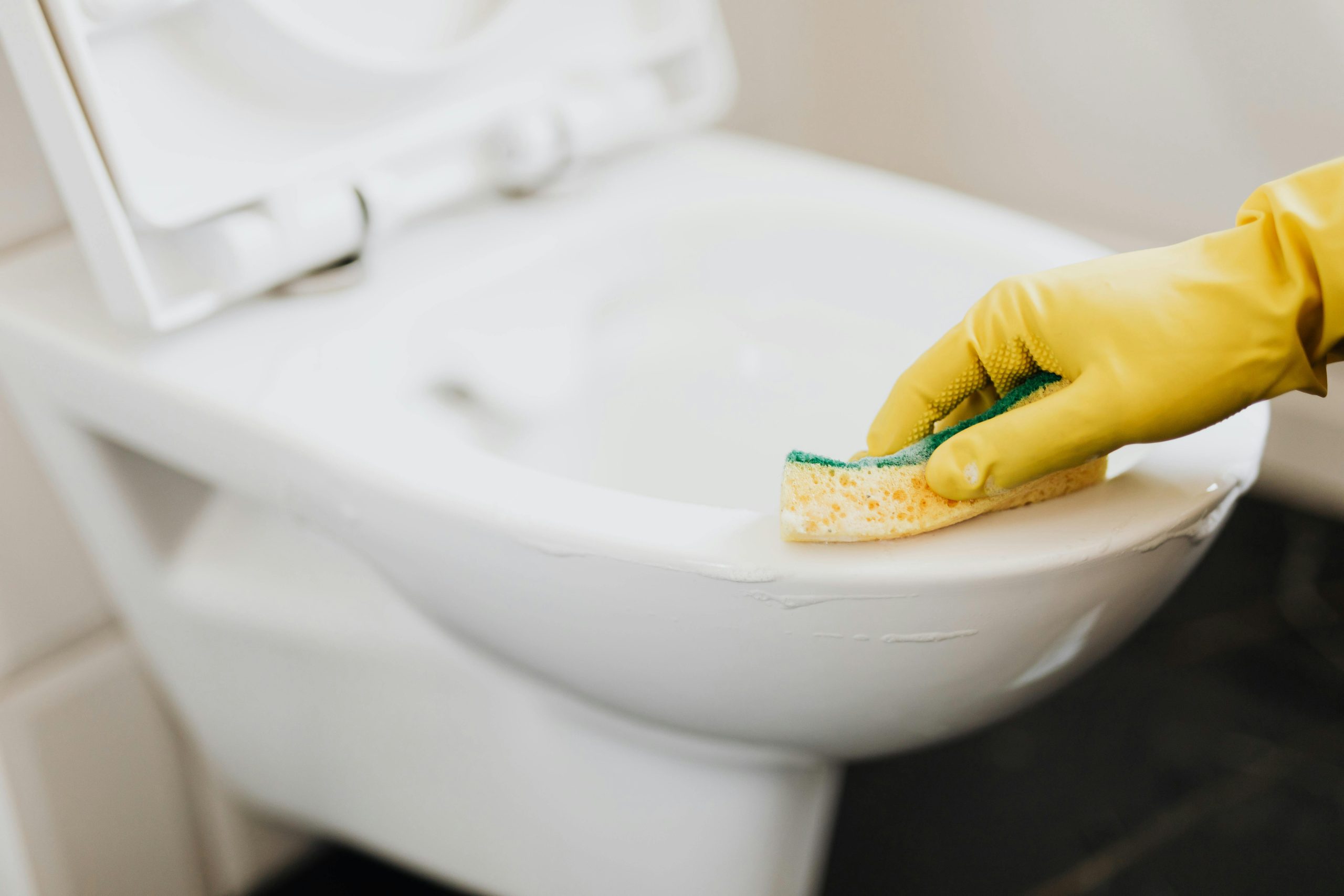 Cleaner scrubbing toilet during commercial bathroom cleaning service in Beenleigh